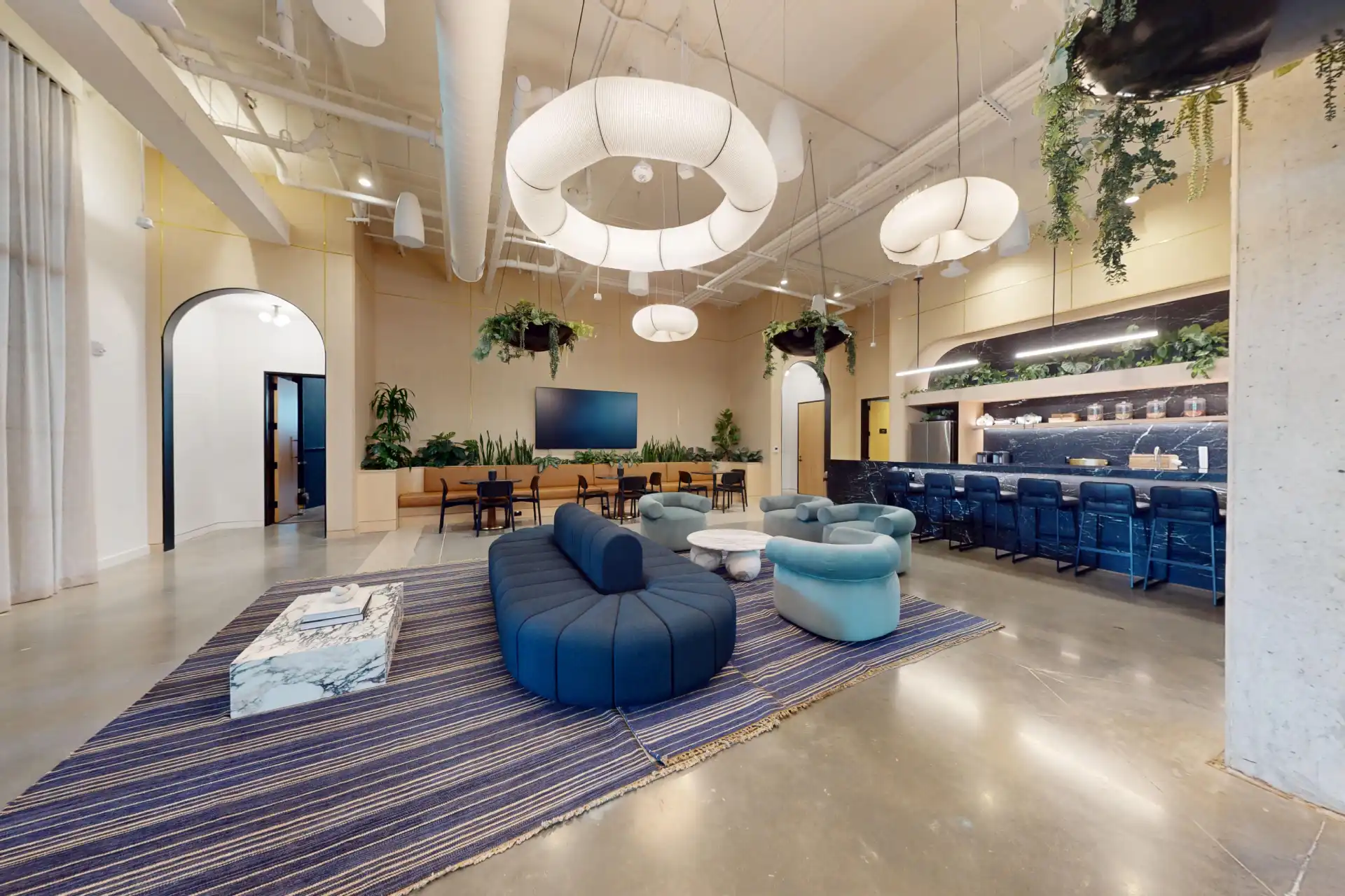 Inside WellSuite — modern wellness lounge with biophilic plant wall